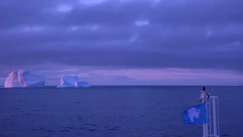 An Antarctic Flag Flutters in the Breeze from the Bow of a Ship Sailing into Stock Footage 346168195