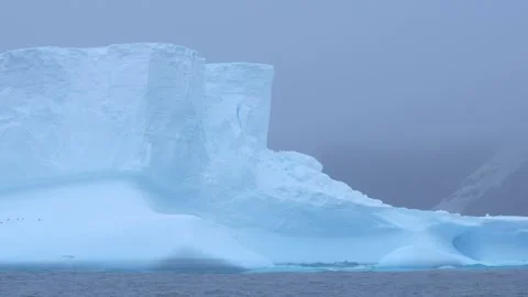 Antarctica Close Up Massive Blue Iceberg Floats in Frozen Ocean Waters. Mis.. Stock Footage 340303266