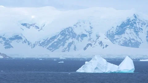 Antarctica Icebergs Float Past Land of Snow and Ice Mountains Stock Footage 277919794