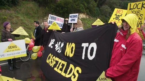 Anti-fracking protesters holding sign An unconventional gas protest. Stock Footage 87645480
