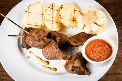 Anticuchos, Peruvian cuisine, grilled skewered beef heart meat with boiled po Stock Photos