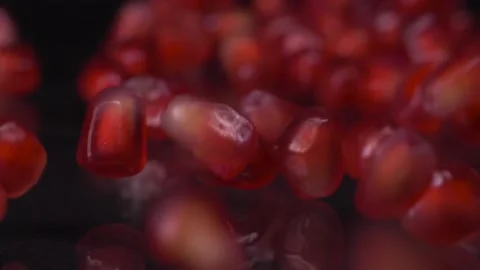 Antioxidant benefits. Super slow motion shot of pomegranate seeds falling and Vídeos de archivo 147411341
