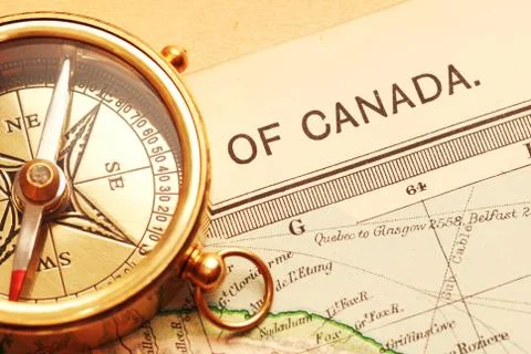 Antique brass compass over old canadian map Stock Photos