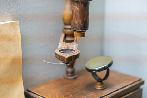 Antique brass microscope on light surface in a pharmacy setting Shallow dep.. Stock Photos