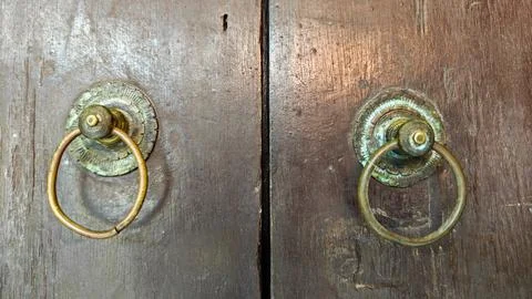 Antique Brass Ring Pulls on Weathered Traditional Indonesian Wooden Doors Foto stock