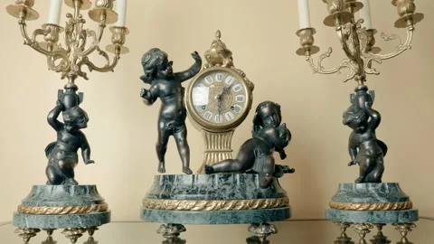 Antique bronze mechanical clock with angels and candlesticks on a stone base  Stock Footage 121604777