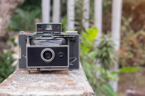 An antique camera placed on a concrete wall Stock Photos