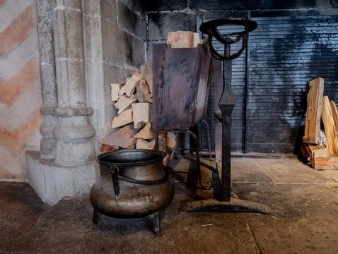 Antique Cauldron with Fireplace Tools in Medieval Kitchen, Historic Interior Sce Stock Photos