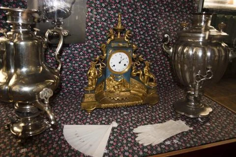 Antique clock and samovar on a table in a shop Stock Photos