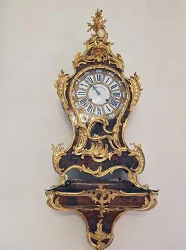 An antique clock is fixed on a wall in the hall of Rundale Castle in Latvia o Stock Photos