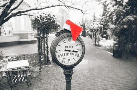 Antique clock with lying on it red Santa hat and the words merry Christmas on Foto stock