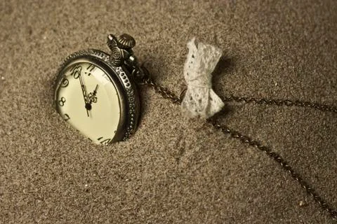 Antique clock in the sand Stock Photos