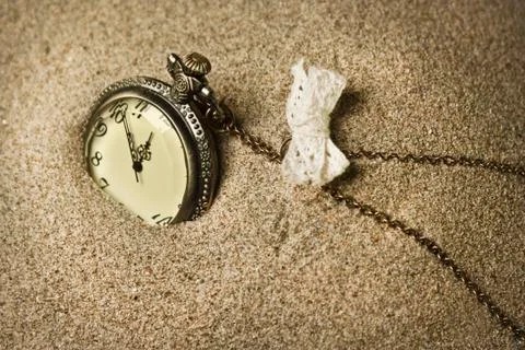 Antique clock in the sand Stock Photos