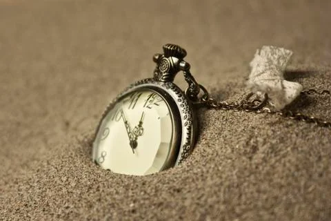 Antique clock in the sand Stock Photos