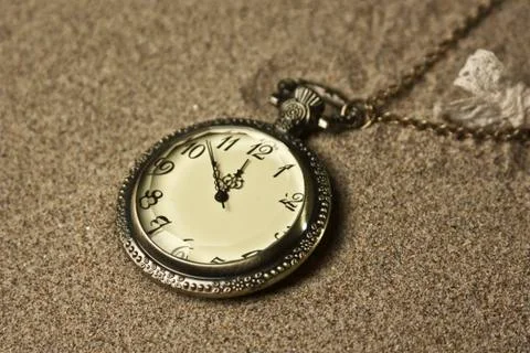 Antique clock in the sand Stock Photos