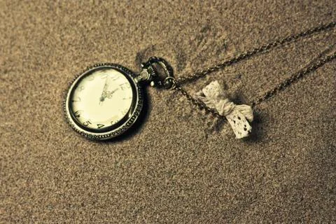 Antique clock in the sand Stock Photos