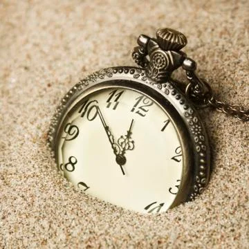 Antique clock in the sand Stock Photos