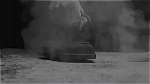 ANTIQUE CLOTHES IRON WORKING.  ECU, 4K, BLACK AND WHITE, KINESCOPED. Stock Footage 233728483