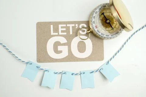 Antique compass with a card of Let's Go text on a white background. Concept.. Foto stock