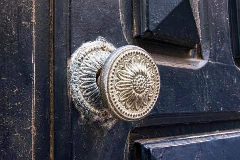 Antique door handle in flower pattern. Worn and dirtied over time Photos