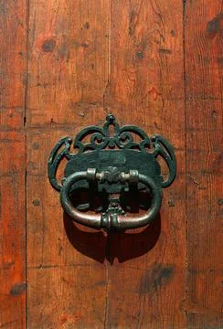 Antique door knocker decorating a rustic wooden door Stock Photos