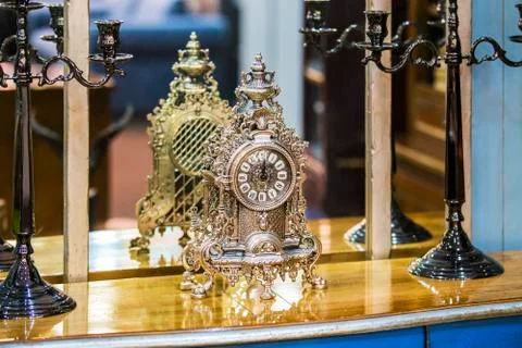 Antique expensive silver old clock on the chest of drawers. Stock Photos