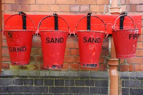 Antique fire buckets on hooks at a train station  Stock Photos