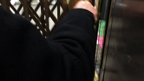 Antique grid elevator going up one floor. Grid close up with a shoulder on the Stock Footage 92570895
