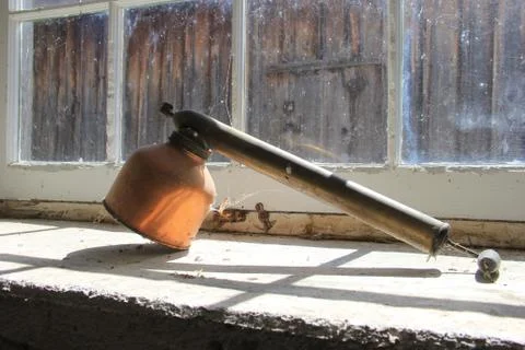 Antique hand pump bug sprayer on the window of a barn Foto stock