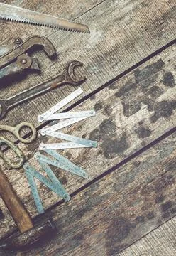 Antique hand tools arranged on a rustic wooden surface for an art project or Stock Photos