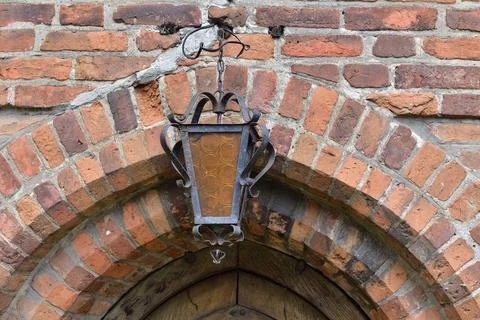 An antique lamp hanging on a brick wall. Summer. Day. Stock Photos