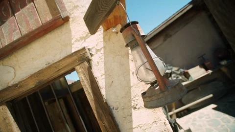 Antique lantern gently blows in breeze outside "Wild West" jail, Pioneertown. Stock Footage 113750297