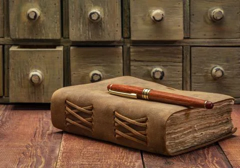 Antique leather-bound journal on rustic table Stock Photos
