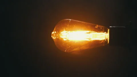 Antique Light Bulb Flashes Orange in Fog on Black Background Stock Footage 263827928