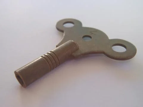 Antique old fashioned clock key Stock Photos