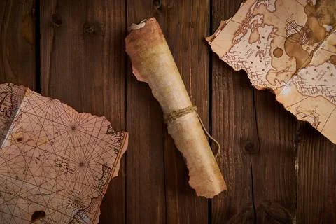 Antique parchment scroll with old maps on a wooden table. Stockfoto's