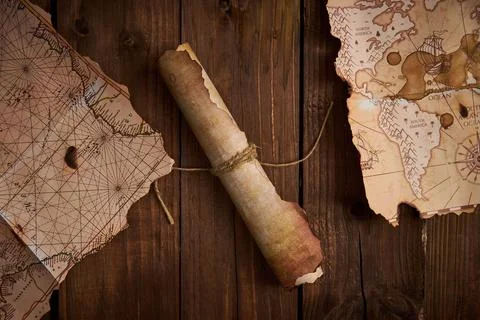 Antique parchment scroll with old maps on a wooden table. Stockfoto's