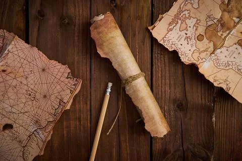Antique parchment scroll with old maps on a wooden table. Stockfoto's