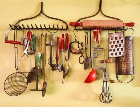 Antique, rustic kitchen utensils on a wall as decor Stock-Fotos