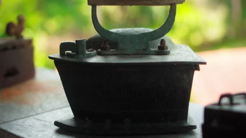 Antique rusty charcoal iron for ironing clothes with wooden handle stands o.. Stock Footage 304472990