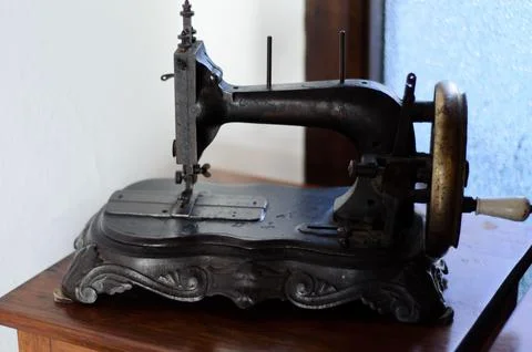 Antique sewing machine by a sunlit window Stock Photos