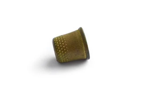 An antique thimble lies on its side isolated on a white background Stock Illustration