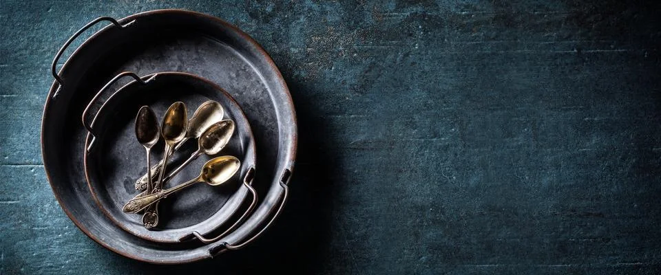 Antique trays with spoons on a rustic table - Top of view banner with copyspa Stock Photos