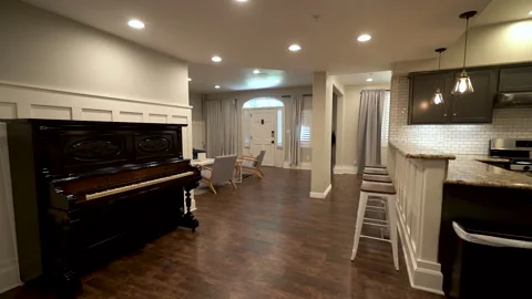Antique upright piano in open plan home with kitchen bar Stock Footage 345689253