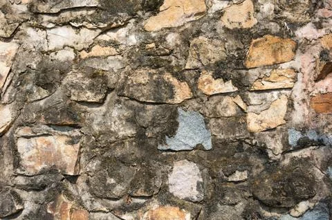 Antique wall made of multi colored rocks Stock Photos