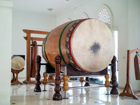 An antique wooden drum rests on its ornate stand inside a bright, white-wal.. Stock Photos