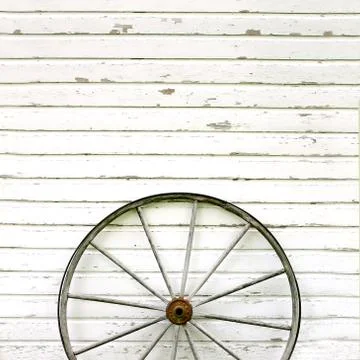 Antique wooden wagon wheel on rustic white background Stock Photos