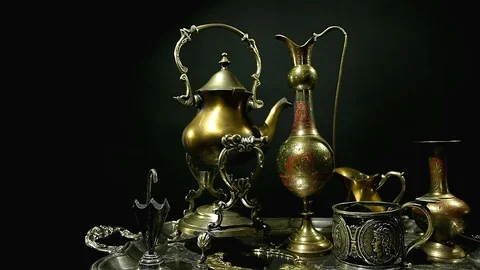 Antiques on an old silver tray on a dark background. Many different antiques. Stock Footage 98718341