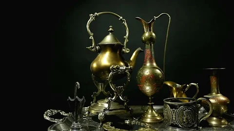 Antiques on an old silver tray on a dark background. Many different antiques. Stock Footage 98718344