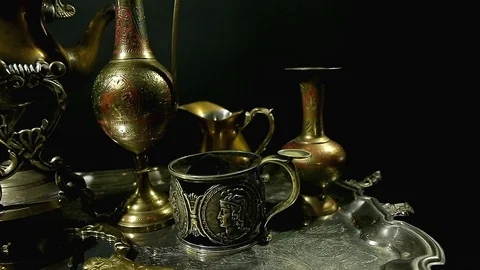 Antiques on an old silver tray on a dark background. Many different antiques. Video stock 98718366